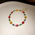 Gros plan de pierres de zircon ovales multicolores sur un bracelet plaqué or - Ovale / Coloré