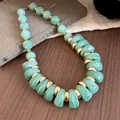 Detalle macro de cuentas de acrílico verde y espaciadores de metal dorado en collar. - Verde