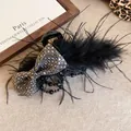 Vintage-style black hair claw clip featuring a rhinestone bow and black feather accents - Feather Claw Clip / Black