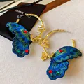 Detailed close-up of luxury embroidered butterfly gold hoop earrings with shiny gemstones - Embroidery Butterfly Style (HE21906) / Gold-Blue