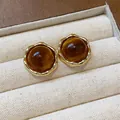 Macro view of amber resin stud earrings with gold scalloped borders on linen - Scalloped Round (Real Gold Plated) / Brown