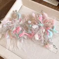 Vista detallada de pendientes de flores de lana en tonos pastel con perlas - Rosa