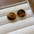 Detail view of round resin stud earrings with golden rope border in Maillard style - Textured Round (Real Gold Plated) / Brown