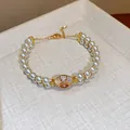 Detailed macro view of a luxury double-strand pearl bracelet with zircon centerpiece - Bracelet / Gold