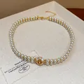 Close-up view of elegant 18k gold plated double strand pearl necklace with a zircon centerpiece - Necklace / Gold