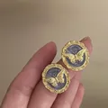 Close-up of vintage gold butterfly stud earrings with purple marble enamel detail - Vintage Round Butterfly Style (1#) / Gold / Purple