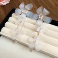 Dettaglio che mostra i delicati fiori in chiffon bianco e i dettagli in perline - Bianco