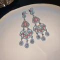 Gros plan de boucles d'oreilles de style palais avec perles et pierres roses - Argent-Bleu-Rose