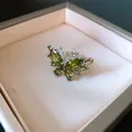 Primo piano di un anello a farfalla in argento con zirconi verdi brillanti e rifiniti - Design a Farfalla / Argento-Verde