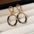 Close-up of black enamel and gold oval drop earrings in a luxury jewelry box display - Silver Earring Post - Gold - Black