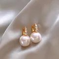 Elegant gold pearl drop earrings with crystal accents on a luxurious satin background. - Gray Vintage Style (20#)