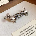 Détail exquis d'une broche teckel en argent avec décoration de fil tissé tricolore - Argent