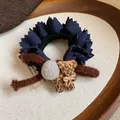 Detail shot of navy blue ruffled lace hair tie with flocked leopard bear and gray pom-pom - Blue