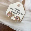 Detailed view of 18k gold-plated pink flower clip-on earrings with pearl accents - Clip-On Earrings / Gold-Pink