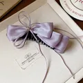 Detail view of a lavender satin bow hair clip with a small gold star stud - Bow Banana Clip / Single Piece / Purple