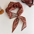 Vue détaillée d'un foulard bandana marron à motif cachemire noué avec élégance - Style 21#