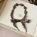 Détail d'un collier écharpe léopard avec d'élégantes perles brunes dans un coffret - Style 28