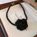 Close-up of French style black fabric rose necklace with beaded chain on display box - Necklace / Black