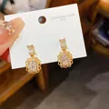 Elegant gold-toned flower frame stud earrings with central crystal center displayed on card - 53# Silver Needle - Gold - White (genuine Gold Plated)