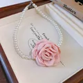 Close-up detail of an elegant pink fabric rose flower and white pearl beaded choker necklace - Necklace / Pink