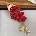 Detailed close-up of a red fish-shaped hair clip with gold accents and evil eye detail - Fish Shaped Duckbill Clip / 1 Piece / Gold Red Sequin Fish Left