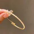 Vue détaillée d'un élégant jonc doré orné de zircons scintillants pour femmes - Ajustable / Or