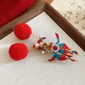 Close-up detail of festive red pompom hair clip with enamel carp and pearl accents - Pearl Tassel Duckbill Clip / 1 Piece / Gold Red Large Fur Ball