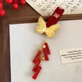 Close-up of festive red velvet hair clip with gold butterfly and Wealth character detail - BB Clips / 1 Piece / Gold Cai Character Butterfly Tassel