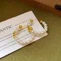 Elegant C-shaped gold-tone pearl hoop earrings featuring delicate white glass beads on a card - 59# Silver Needle - Gold - White (genuine Gold Plated)