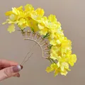 Detailed macro shot of a yellow fabric flower hairpin with a gold U-shaped metal base - Yellow