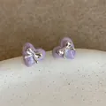 Detailansicht der lila Herzohrringe mit Marmor-Finish und silberner Schleife als Akzent - Violett/Silber (Silberstift)