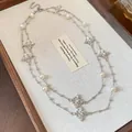 Detailed view of a double-layered silver necklace with pearls and rhinestone crosses. - Pearl Cross (WN2080) / Silver-Beige