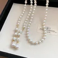 Close-up of a French vintage multi-layer pearl necklace with elegant teardrop pendants - Necklace - Gold - White
