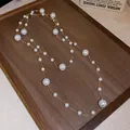 Elegant French retro irregular pearl necklace with delicate gold chain on a wooden tray display. - Gold-White