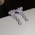 Detailed macro view of sparkling crystal flower drop earrings with elegant water-drop tassels - Vintage Rhinestone Flower Cluster Earrings / Silver Earring Post Style / Silver