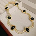 Vintage gold palace style necklace featuring oval black gemstones in a textured setting - Necklace / Gold-Black