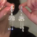 Close-up of sparkling silver bow earrings with pearls and long diamond-set tassels - Bow Knot Pearl Bell (30#) / Silver