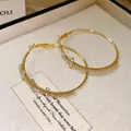 Elegant gold-finish hoop earrings with sparkling rhinestone cross charms - Gold