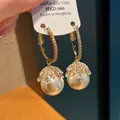Close-up detail of luxury pearl earrings with crystal clusters on golden hoop frame - Flower Geometric Style (HE4664) / White