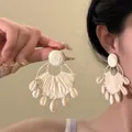 Detailed view of bohemian style rattan woven fan-shaped earrings with cowrie shell pendants - 15#White