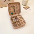 Primer plano de un joyero de cuero portátil con espacio para anillos y collares - Joyero (AQ101) / Rosa