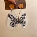 Close-up of bohemian butterfly wing print wooden teardrop earrings shown on a card - 30# White Black