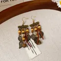 Close-up of boho vintage earrings with metal leaves, wood beads, and leather tassels. - 34# Antique Gold