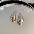Primer plano de alta calidad de pendientes de gota de agua de plata minimalistas brillantes - Forma de gota de agua / Plateado