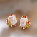 Nahaufnahme eleganter Monet-Garten-Ohrringe mit Barockperlen und Emaille-Blumen - Stil mit Silber-Ohrstecker / Gold, Weiß