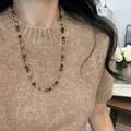 Dettaglio di una collana lunga con perle in occhio di tigre su maglione marrone. - Perline Multicolore Retro Oro (19#)