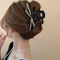 Detailed view of a stylish black rhinestone bow hair claw clip holding a bun elegantly - Rhinestone Decoration / Black Rhinestone Embellished