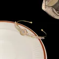 Macro view of gold-tone cuff bracelet adorned with sparkling clear baguette zircons - Round / Gold