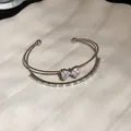 Close-up view of double-layer silver cuff bracelet with sparkling zircon butterfly charm - Bowknot Double Layer / Silver