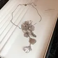 Detailed view of silver metallic hollow flower necklace with sparkling rhinestone centers - Hollow Flower Necklace (HN8635) / Silver
